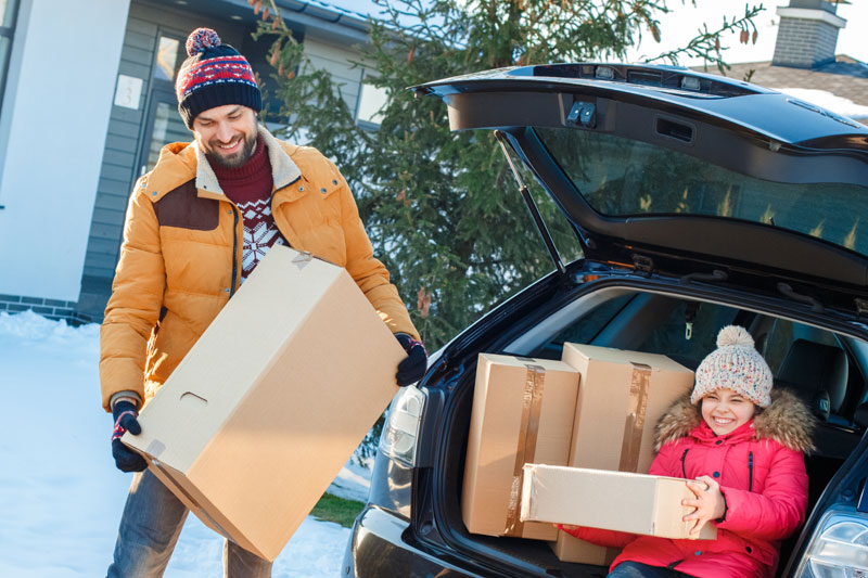 Photo of man loading boxes into the boot of his car